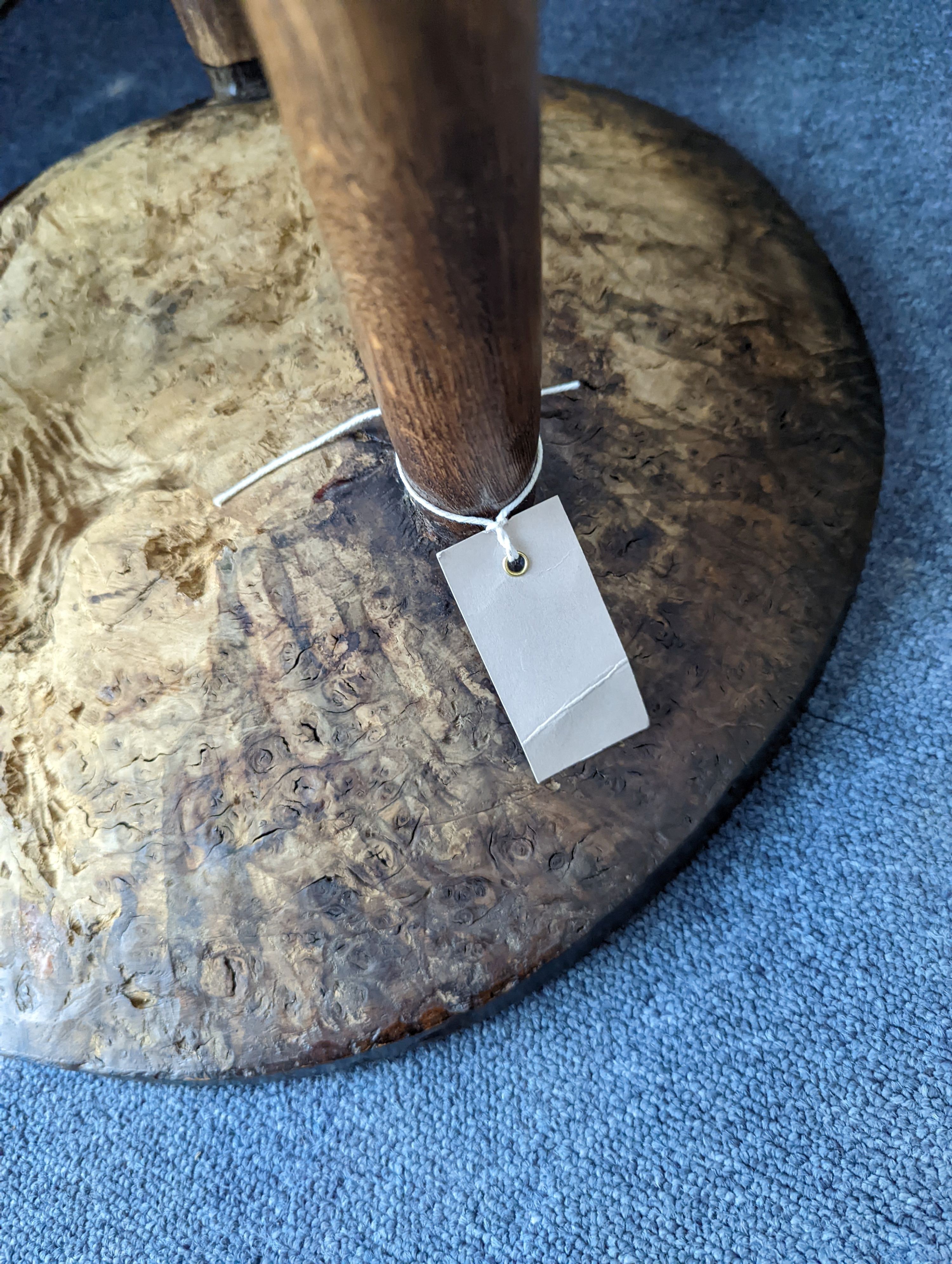 A circular burr elm and ash primitive cricket table with T shaped stretcher, diameter 44cm, height 61cm